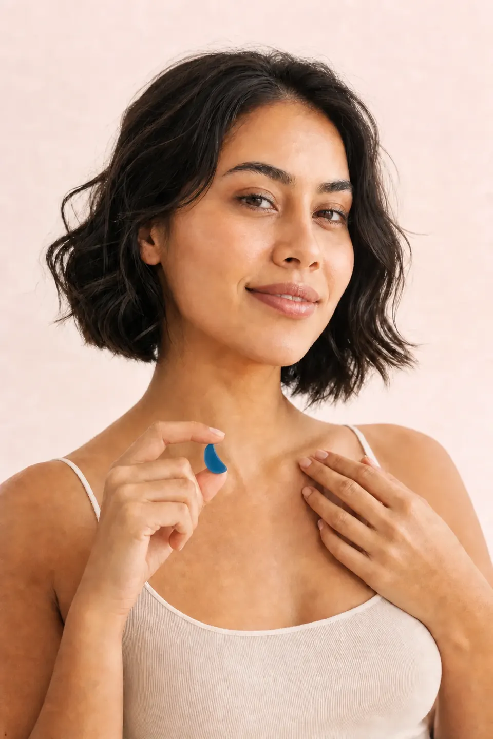 Mujer mostrando una gummy azul en forma de media luna como parte de su ritual diario